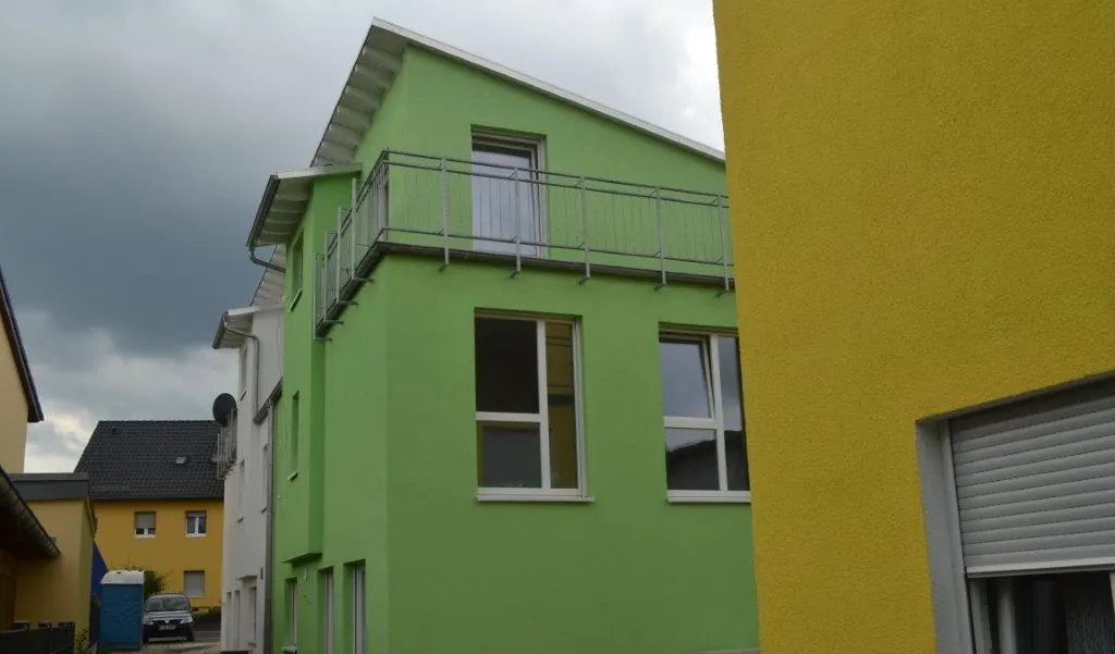 Farbig gestaltete Fassade in Grün und Gelb
